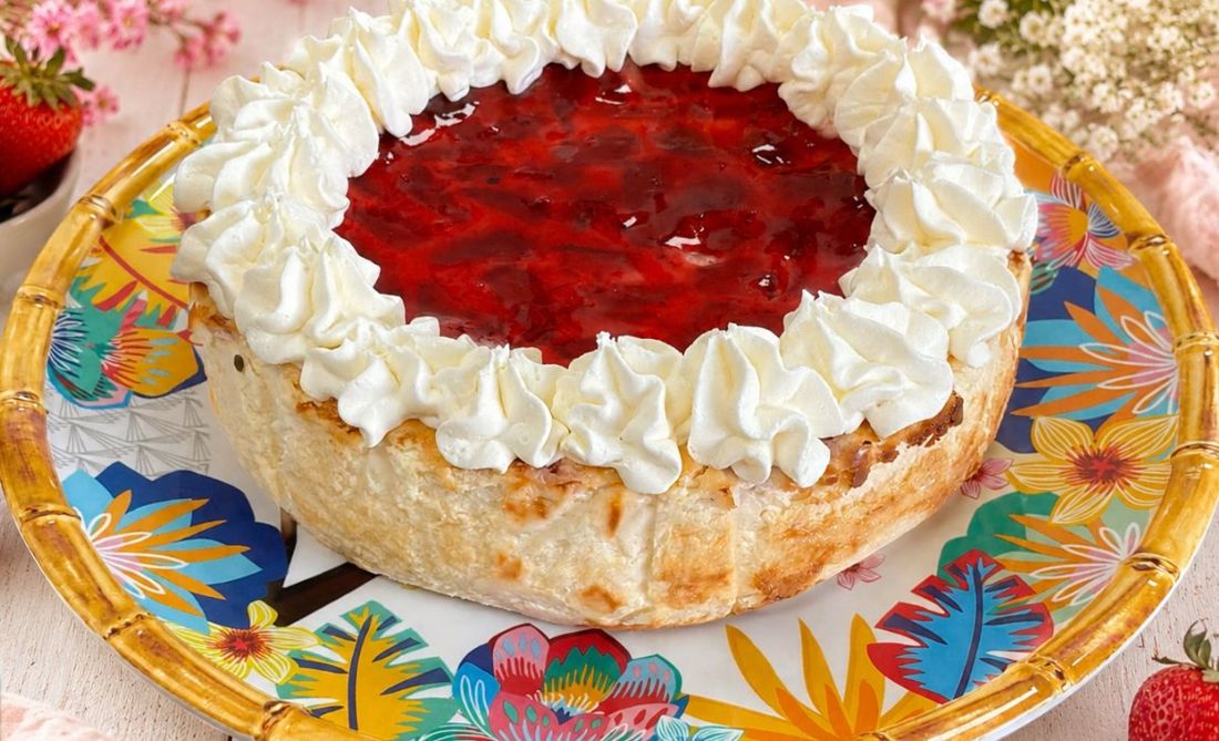 Tarta de queso con mermelada de fresa en el centro y una corona de nata